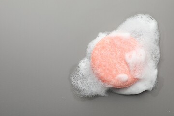Soap bar with foam on grey background, top view. Space for text