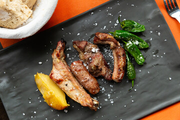 Appetizing grilled assorted meat served with green pepper on slate