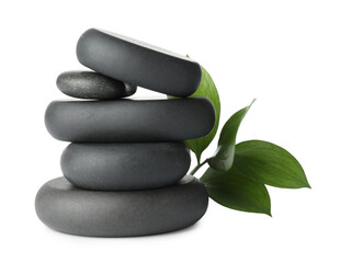 Stacked spa stones and green leaves isolated on white