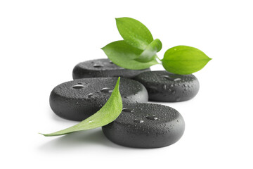 Wet spa stones and green leaves isolated on white