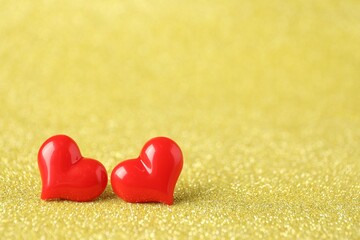 Obraz premium Red decorative hearts on shiny golden background, space for text. Happy Valentine's day