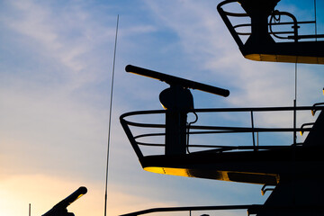 silhouetted ship radar and antennas at sunset.