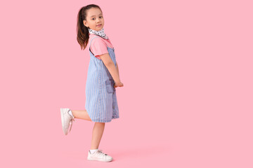 Portrait of fashionable little girl on pink background