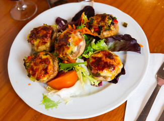 Baked in oven mushrooms stuffed with vegetables, ham and mozzarella