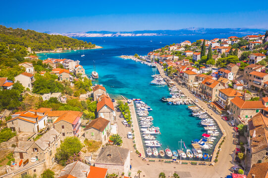 A picturesque view of Stomorska on Solta Island, Croatia, featuring its scenic harbor, moored boats, and traditional stone houses along the waterfront, creating an inviting summer atmosphere.