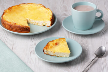 Delicious homemade cottage cheese casserole served with a warm cup of hot beverage on a wooden table
