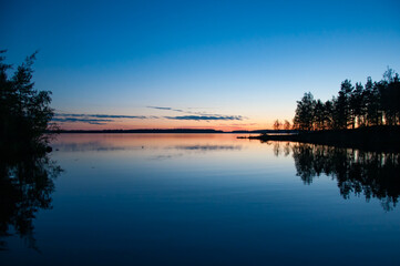 Fototapeta premium Early summer night by a calm lake in Finland
