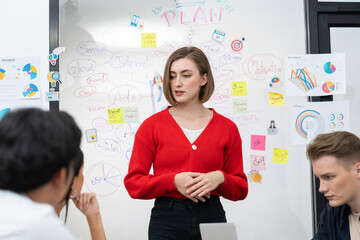 Professional attractive female leader presents creative marketing plan by using brainstorming mind mapping statistic graph and colorful sticky note at modern business meeting room. Immaculate.