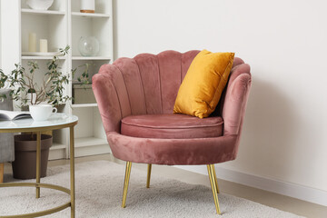 Stylish living room with cozy armchair, shelving unit, coffee table and lamp