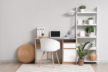 Electric fan on shelving unit with laptop at workplace