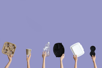 Female hands holding different garbage on lilac background. Recycling concept