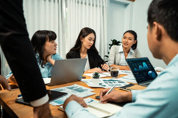 Diverse group of business analyst team analyzing financial data report. Finance data analysis chart and graph dashboard show on TV screen in meeting room for strategic marketing planning. Habiliment