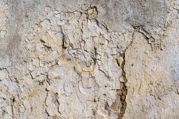 textured background of an old wall with cracked and peeling paint.