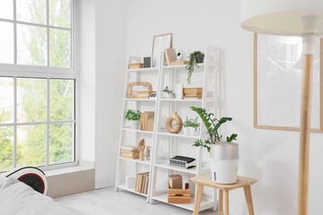 Shelving unit with modern air purifier, books and decor in light living room