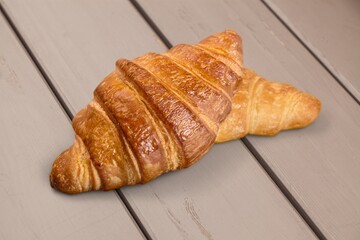 Freshly baked tasty sweet croissant on desk