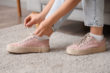 Naklejka premium Woman in pink sneakers at home, closeup