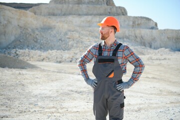 Worker in hardhat standing in stone quarry