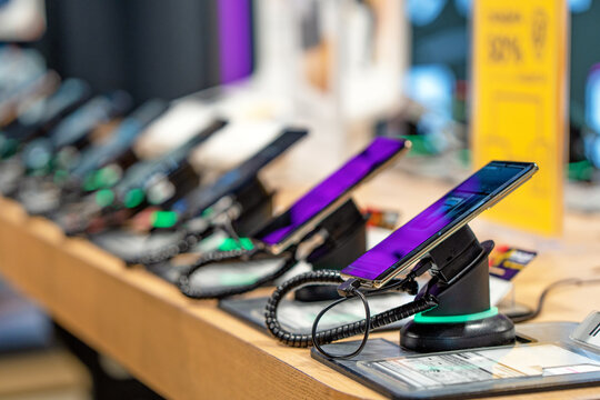 Showcase with smartphones in the modern electronics store. Buy a mobile phone. Many smartphones on the shelf of the technology store