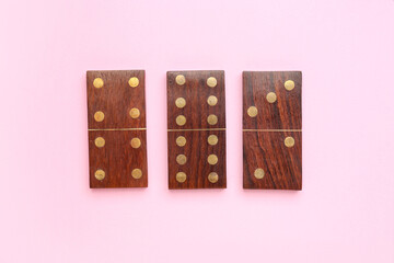 Wooden dominos blocks on pink background