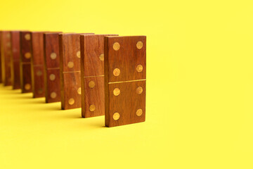 Wooden dominos blocks on yellow background