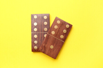 Wooden dominos blocks on yellow background