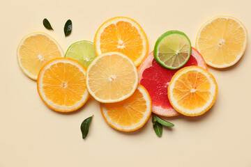 Different citrus slices and leaves on beige background