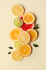 Different citrus slices and leaves on beige background