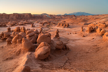 Whimsical hoodoos in Goblin Valley State Park, Utah. Henry Mountains are in the distance.