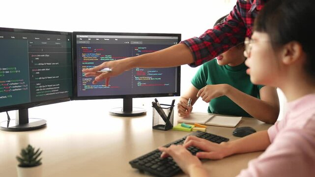 Slow motion back end software developer engineer for computer programming working together on debugging writing computing code, solving complex algorithms display on monitor in office. Burgeoning