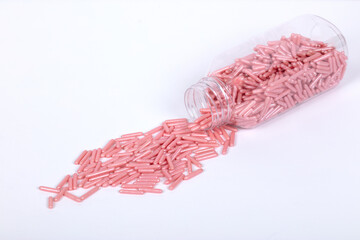 Transparent Plastic Container Filled with Pink Sugar Pearls: Minimalist Still Life Photography of Decorative Sprinkles for Baking