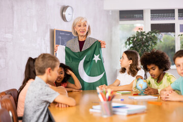 Fototapeta premium listening to teacher s story about Pakistan, child examines this country on globe