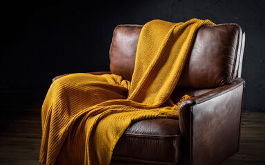yellow knitted blanket on a leather armchair