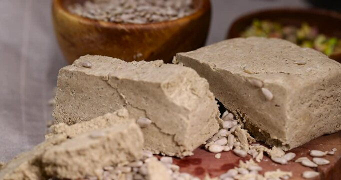 halva from roasted sunflower seeds and crushed into one solid mass, wooden bowl, a sweet delicious dessert made from fried sunflower seeds