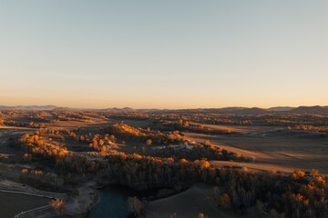 Golden hour over a vast landscape with rolling hills and winding river during autumn