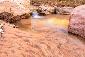 USA, Utah, Glen Canyon National Recreation Area. Scenic pool with rocks and sand.