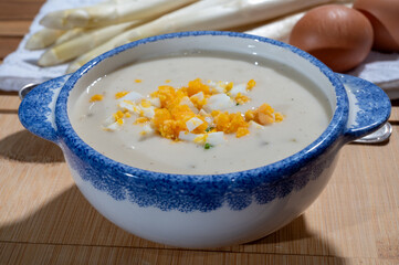 Spring season, homemade soup from raw white asparagus and cooked eggs, new harvest of Dutch, German white asparagus