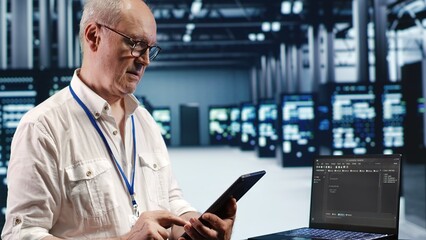 IT solutions expert in data center environment, solving tasks on tablet while running scripts on...