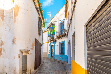Fototapeta premium A whitewashed alley with colorful accents and balconies in the Juderia Jewish Quarter of the historic old town of Cordoba, Spain.