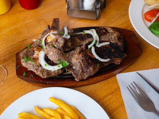Delicious grilled beef steak and cooked French fries.