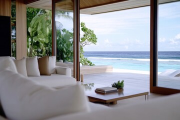 A beautifully designed interior presents a cozy space with large glass windows that open to breathtaking ocean views, merging the indoors with nature's splendor.
