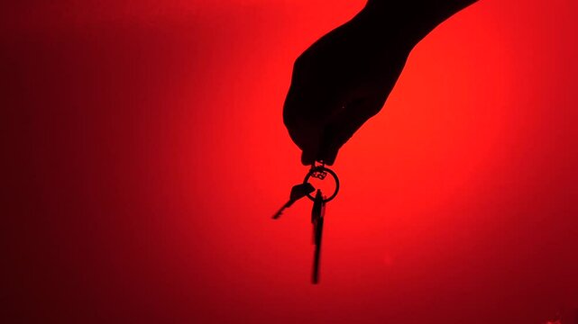 Hand holding keys on a red background