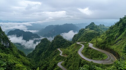 Scenic mountain pass with winding road and cloud inversion shrouded peaks