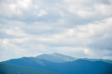 Tranquil view of lush green hills and mount Pip Ivan Chornohora with ruined observatory on the peak...