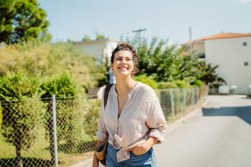 Young caucasian woman is going to the beach with straw bag	
