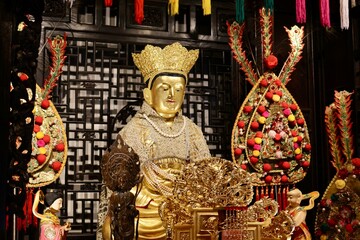 Ornate golden statue adorned with colorful decorations, symbolizing reverence and spirituality in...