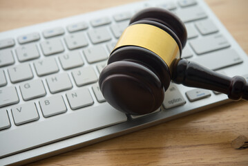 Judge hammer gavel on computer keyboard wooden table background. Online internet crime and scammer,...