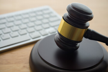 Judge hammer gavel with computer keyboard on wooden table background. Online internet crime and...