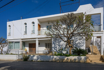 Modern architectural beauty amidst serene surroundings in a sunny coastal neighborhood