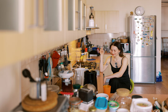 Portrait Of Young Woman Wearing Black Dress On The Kitchen .