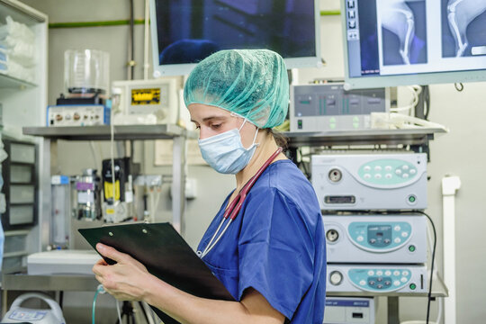Vet surgeon in uniform writing in clipboard in hospital - Powered by Adobe